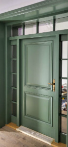 Drewniane drzwi dębowe zewnętrzne w kolorze khaki (NCS S 6010-G30Y) z naświetlami z lustrem weneckim.