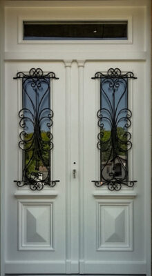 Dwuskrzydłowe drzwi drewniane zewnętrzne z ekskluzywnymi zdobieniami, gzymsami i metaloplastyką. Drzwi białe do Willi, Rezydencji.