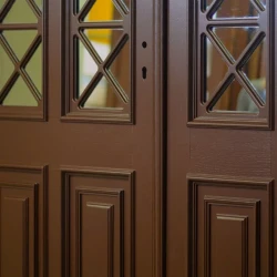 Drzwi dębowe zewnętrzne w kolorze RAL 8017 z kratownicami na szybach i listwami ozdobnymi.