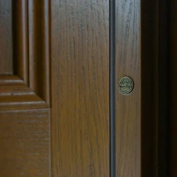 Fragment dębowych drzwi dębowych zewnętrznych w kolorze Orzech z listwą ozdobną.