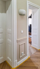 2 pary białych stylowych drzwi drewnianych z ościeżnicami płycinowymi w pięknym wnętrzu.